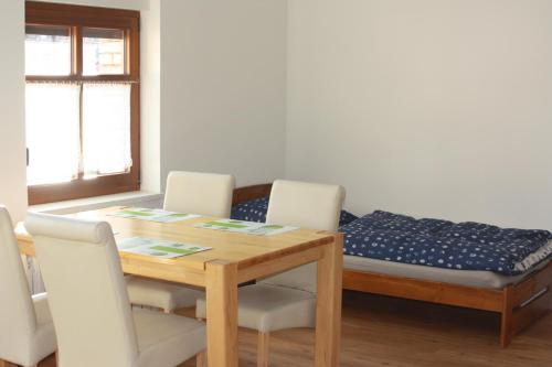 a dining room with a table and chairs with a bed at Ferienzimmer Tielesch in Gadsdorf