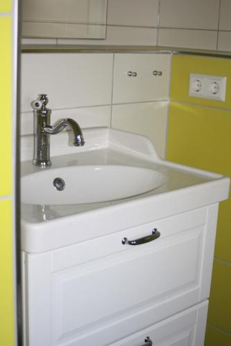 un lavandino bianco con rubinetto in bagno di Ferienzimmer Tielesch a Gadsdorf