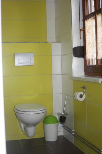 e bagno con servizi igienici e parete verde e bianca. di Ferienzimmer Tielesch a Gadsdorf
