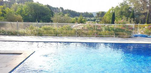 une piscine avec une clôture et de l'eau bleue dans l'établissement La Teze, au Castellet