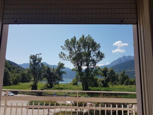 a window with a view of a lake and mountains at Albergo Meridiana in Pergine Valsugana