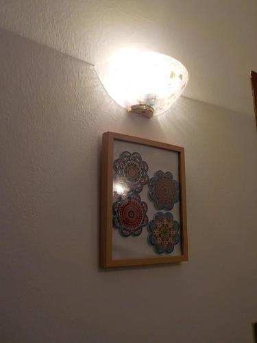 a light on a wall with a picture on it at Casa Romme in Tornolo