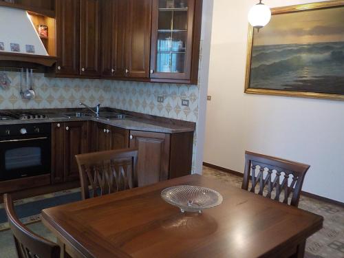 a kitchen with a wooden table with chairs and a sink at Casa Romme in Tornolo