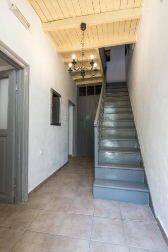 a hallway with stairs and a ceiling with a chandelier at Nisyros Views in Mandrakion