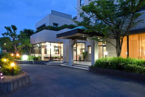 a large white building with lights in front of it at Hotel New Century Sakaide in Sakaide