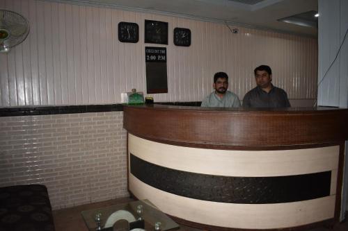 two men standing at a bar in a restaurant at Sitara Hotel in Islamabad