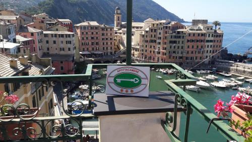 a sign on a balcony of a city with a harbor at La mansarda sul Porto in Camogli