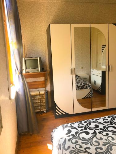 a bedroom with a bed and a cabinet and a tv at DEA in Zugdidi