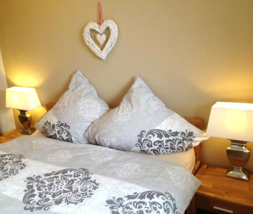 ein Bett mit Kissen und ein Herz an der Wand in der Unterkunft Strandliebe in Scharbeutz