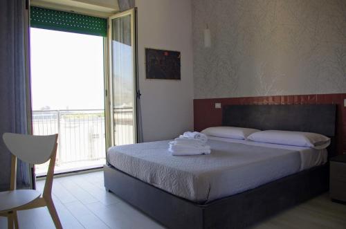 una camera da letto con un letto e asciugamani di Tra cielo e mare a Gaeta
