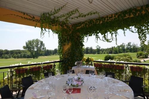 a table with wine glasses and a view of a golf course at Golf Hotel Castelconturbia in Agrate Conturbia