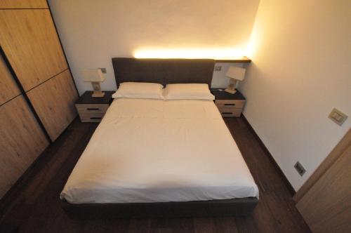 a bed in a small room with two lamps at Appartamento Mia in Orvieto