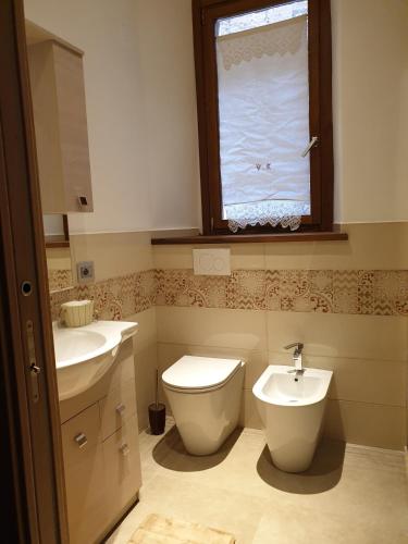 a bathroom with a toilet and a sink and a window at Appartamento Mia in Orvieto