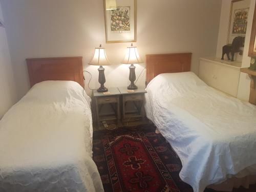 2 camas en una habitación con 2 lámparas y una alfombra en 69 ALBERT STREET, en Saint Albans