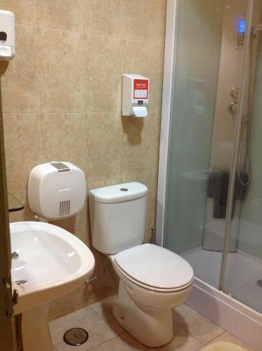a bathroom with a toilet and a sink and a shower at New Aljubarrota Guest House in Lisbon