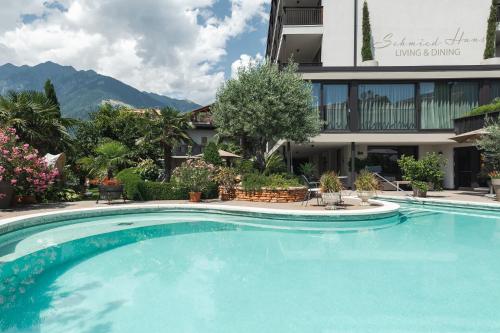 a large swimming pool in front of a building at Hotel - Appartements Schmied Hans in Schenna