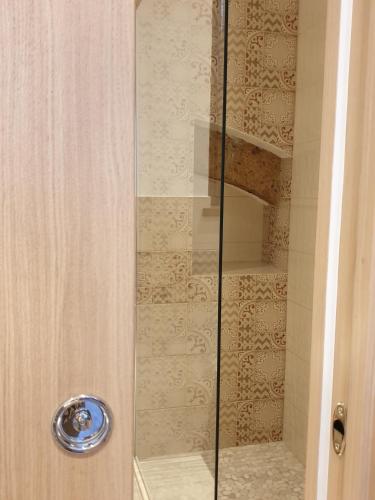 a shower with a glass door in a bathroom at Appartamento Mia in Orvieto