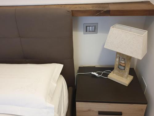 a bedroom with a bed and a lamp on a night stand at Appartamento Mia in Orvieto