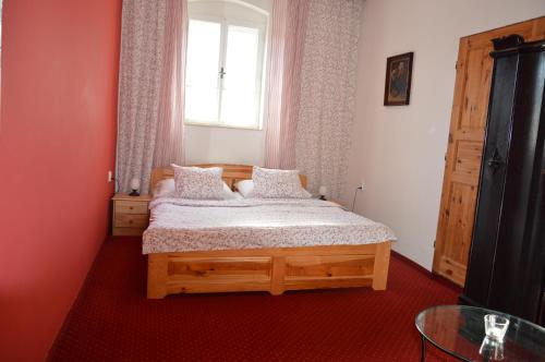 1 dormitorio con cama de madera y ventana en Penzion u Hradilů, en Vrbno pod Pradědem