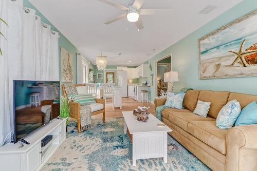 a living room with a couch and a tv at Coral Cottage Retreat in Naples