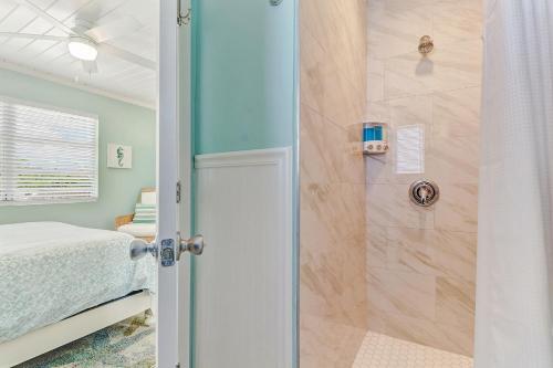 a bathroom with a shower and a bed in a room at Coral Cottage Retreat in Naples