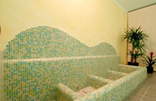 a bathroom with a green tiled tub in a room at Park Hotel Faver in Tremosine Sul Garda