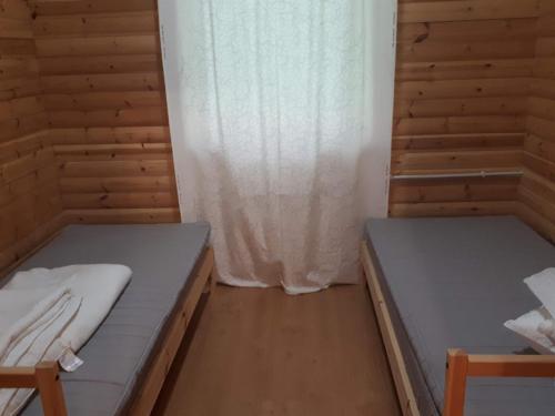 a room with two beds and a window at Коттедж в Финляндии (Тохмаярви) in Tohmajärvi