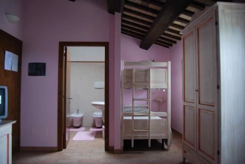 bagno con servizi igienici e parete rosa di Cadabò a Montecarotto