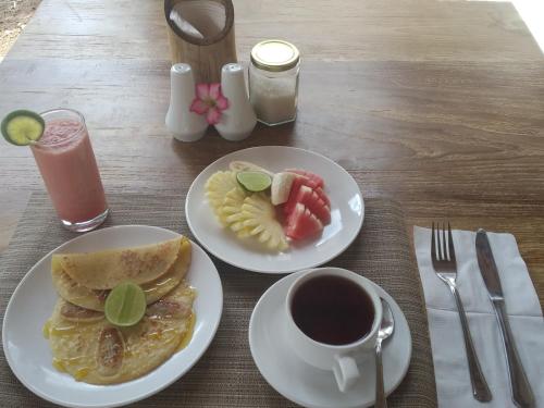 een tafel met twee borden eten en een kop koffie bij HoneyBee Huts in Nusa Lembongan