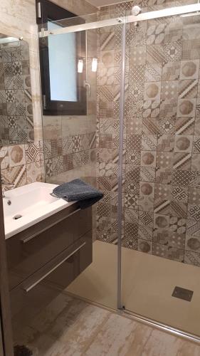 a bathroom with a shower with a sink and a mirror at La Frache in Sainte-Croix-de-Verdon