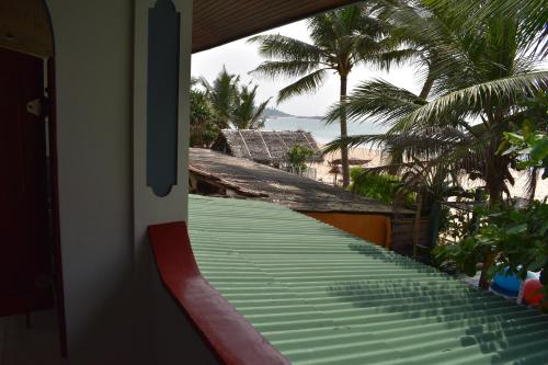 a balcony with a view of the beach and palm trees at Whitepearl Beach in Hikkaduwa
