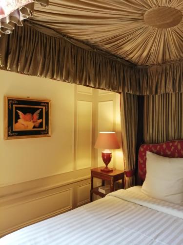 une chambre avec un lit à baldaquin dans l'établissement Domaine de La Brugere, à Nantheuil