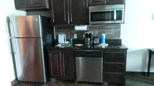 a kitchen with a stainless steel refrigerator and a microwave at Baymont by Wyndham Andrews TX in Andrews