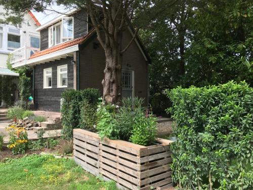 ein Haus mit einem Baum in einer Holzkiste in der Unterkunft Studio Het Kommertjeshof in Burgh Haamstede