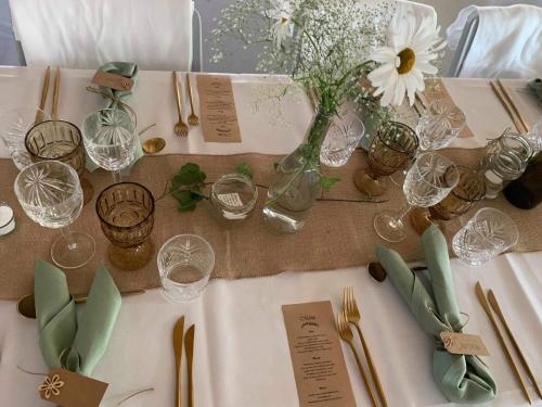 a table with a vase of flowers and wine glasses at 7 Bedrooms Horse Farm near Skagen in Jerup