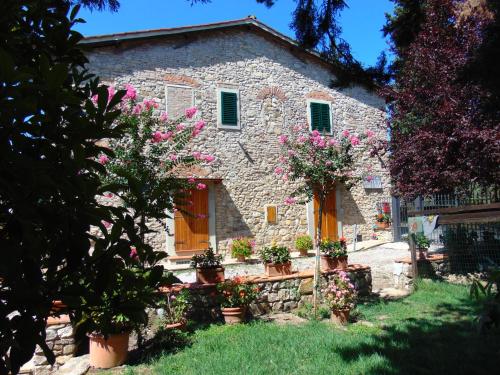 a stone house with flowers in front of it at Agriturismo Circugnano in Grassina