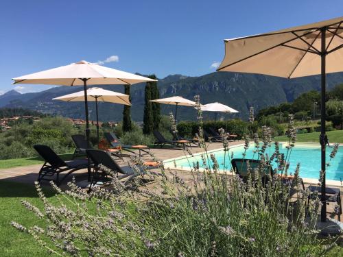 a swimming pool with umbrellas and chairs and a pool at Il Poggio Di Bellagio in Bellagio