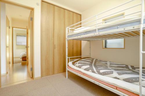 a bedroom with two bunk beds and a hallway at Olina's House in Osaka