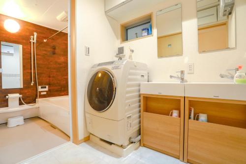 a washing machine in a bathroom with a sink at Olina's House in Osaka