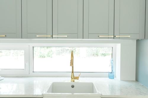 a white kitchen with a sink and two windows at The Peaceful Vacation- Villa M in Muratsi