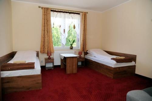 1 dormitorio con 2 camas y ventana en Zajazd Ostoja, en Stary Dzierzgoń
