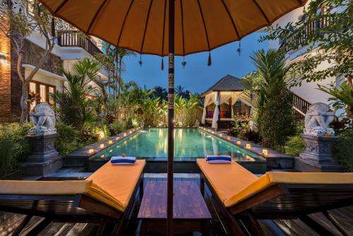 ein Pool mit Sonnenschirm und ein Resort in der Unterkunft Cenik Villa Ubud in Ubud
