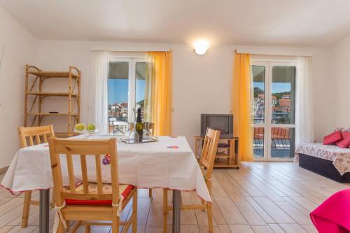 a living room with a table and chairs and a television at Apartments Sanja in Hvar