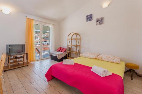 a bedroom with a bed and a tv in it at Apartments Sanja in Hvar