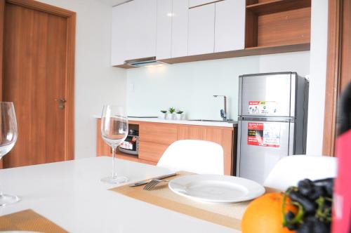 a kitchen with a table with a plate and wine glasses at SAIGON GARDEN HILL Resort & Apartment in Ho Chi Minh City