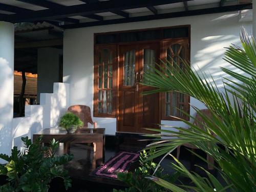 a room with a chair and a table and some plants at Shan Home Stay Sigiriya in Sigiriya