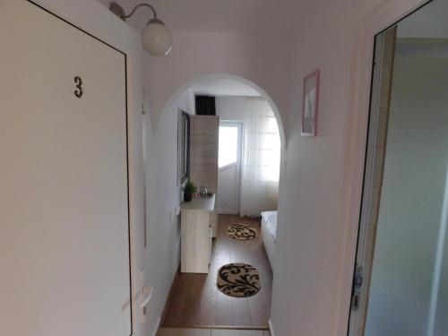 a hallway with an archway in a white room at Pensiunea Casa Domnitei in Baia de Fier