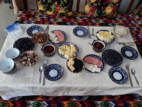 een tafel met blauwe en witte borden met voedsel erop bij Boutique ALISHER in Bukhara