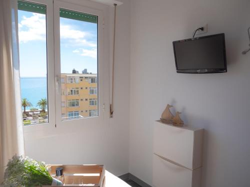 a white room with a television and a window at Hotel Liliana in Varigotti