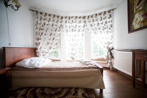 a bedroom with a bed and a window with curtains at Hotel & Spa Arkadia in Tomaszów Lubelski
